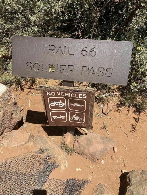 Sign for Trail 66 at Soldier Pass, with a warning against vehicle access, featuring icons of prohibited vehicles.