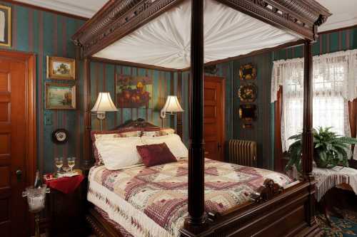 Cozy bedroom with a four-poster bed, quilt, vintage decor, and warm lighting in a charming, historic setting.