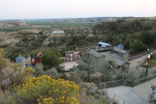 A scenic view of Medora, North Dakota, featuring a western-style town and the Badlands in the background.