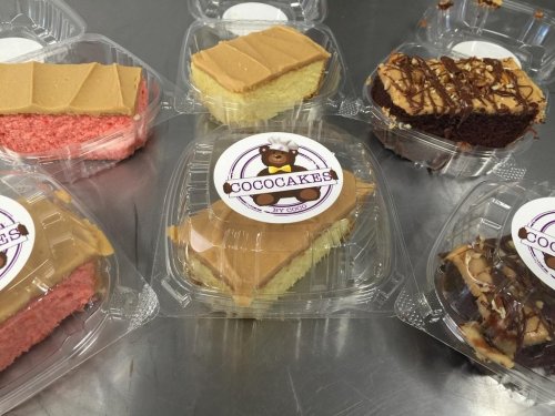 Assorted cakes in clear containers, featuring pink, yellow, and chocolate layers, with a "CocoCakes" label.