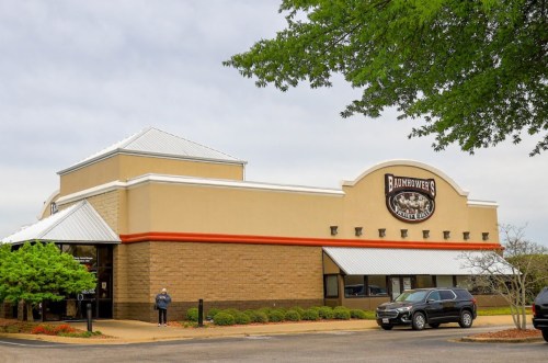 A restaurant building with a sign reading "Badmower's," surrounded by greenery and parked cars.