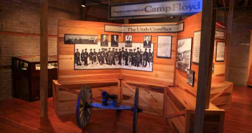 Exhibit at Camp Floyd showcasing the Utah Conflict, featuring historical images and a cannon display.