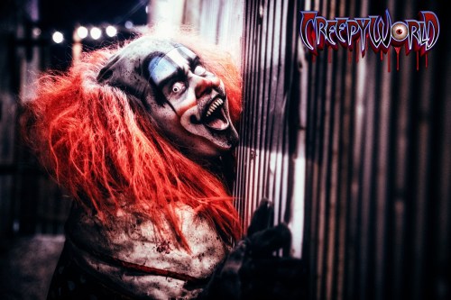 A creepy clown with wild red hair and a sinister grin leans against a wall, set in a dark, eerie environment.