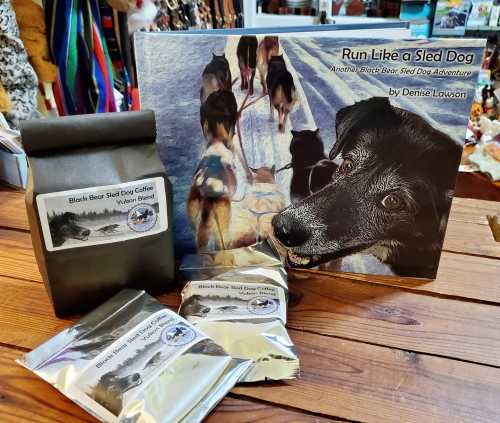 A book titled "Run Like a Sled Dog" by Denise Lawson, alongside Black Bear Sled Dog Coffee packages.