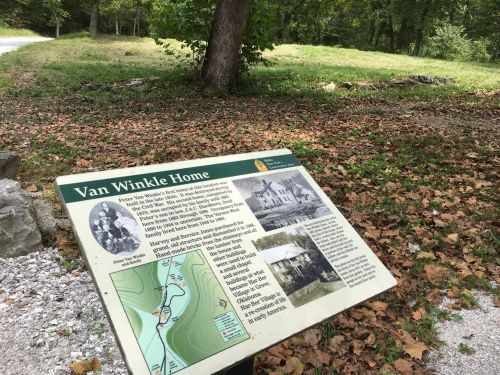 Sign about the Van Winkle Home, featuring a map and historical information, surrounded by trees and fallen leaves.