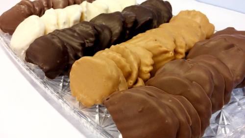 A platter of assorted chocolate-covered cookies in dark, milk, and white chocolate varieties.