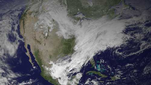 Satellite view of North America, showing land, clouds, and surrounding ocean areas.