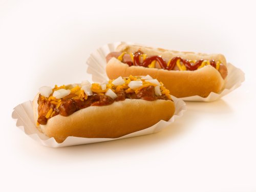 Two hot dogs in paper trays: one topped with chili and cheese, the other with ketchup and mustard.