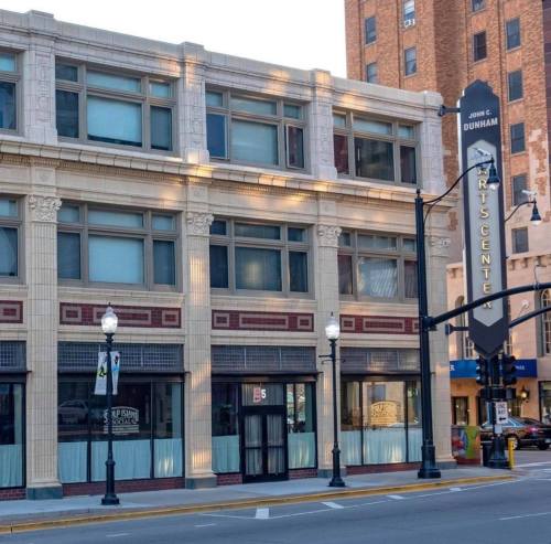 Historic building with decorative architecture, featuring the John C. Dunham Arts Center sign and street lamps.