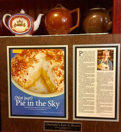 A framed article titled "(Not just) Pie in the Sky" with a photo of a coconut pie, displayed above decorative teapots.
