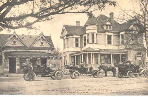 Historic photo of early 1900s cars parked in front of a large Victorian house and office in Benton, Arkansas.