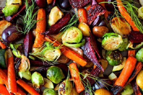 A colorful assortment of roasted vegetables, including carrots, Brussels sprouts, and various root vegetables.