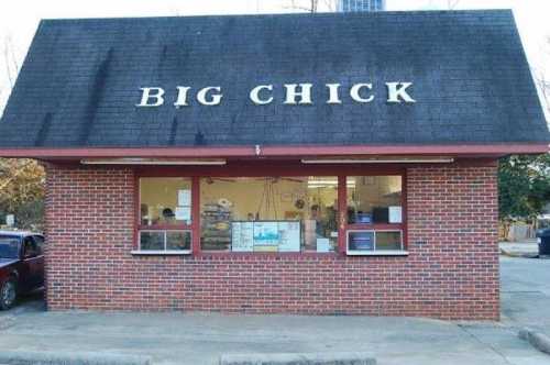 A brick building with a sloped roof, featuring a sign that reads "BIG CHICK" and large windows.