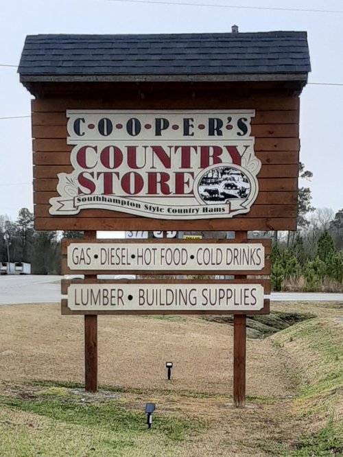 Sign for Cooper's Country Store offering gas, diesel, hot food, cold drinks, lumber, and building supplies.