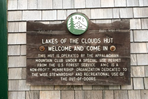 Sign for Lakes of the Clouds Hut, operated by the Appalachian Mountain Club, detailing its purpose and elevation.