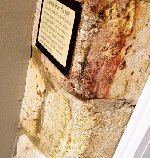 Close-up of a textured stone wall with a plaque titled "Footprint from the Past."