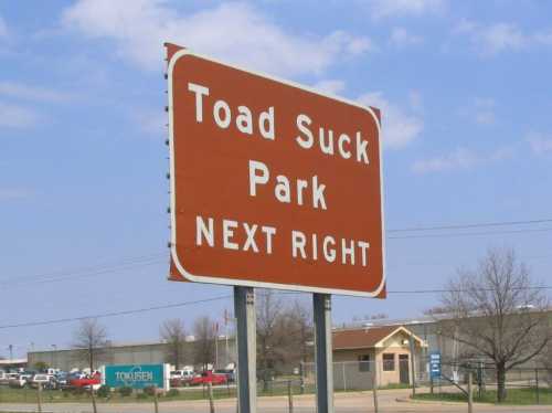 Sign for Toad Suck Park, indicating the next right turn, with a clear blue sky in the background.