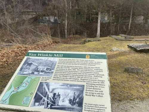 Sign about Van Winkle Mill, with historical information and a view of the surrounding area, partially covered in moss.