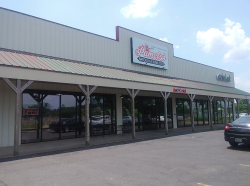 Exterior of a restaurant named "Pamela's," featuring an open sign and a covered entrance. Clear blue sky above.