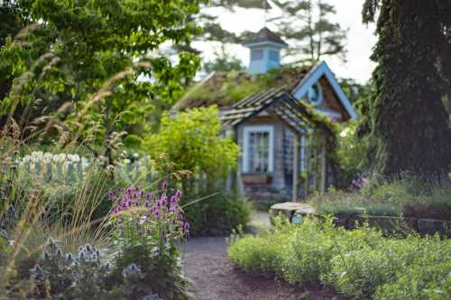 A charming cottage surrounded by lush greenery and colorful flowers in a serene garden setting.