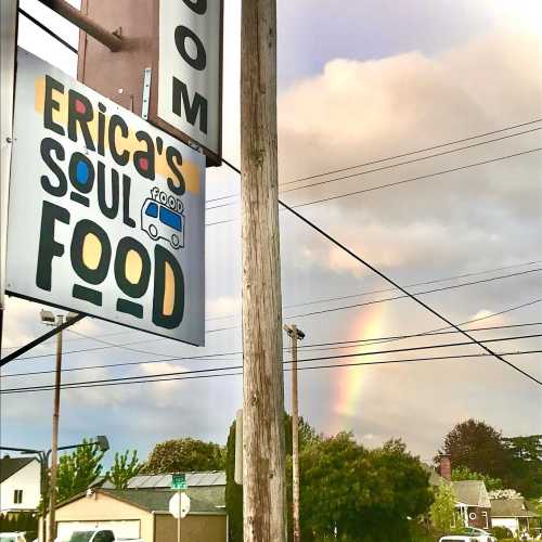 Sign for "Erica's Soul Food" with a rainbow in the background and power lines in the foreground.