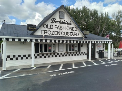 A charming building with a sign reading "Berkshire's Old Fashioned Frozen Custard," featuring a checkered pattern and flags.