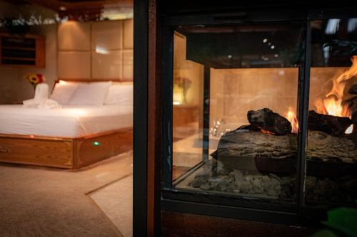 Cozy bedroom with a modern fireplace, featuring a bed and warm lighting for a relaxing atmosphere.