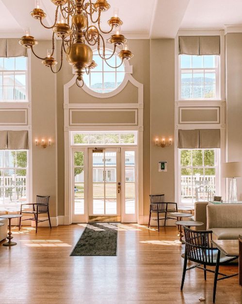 Bright, airy lobby with large windows, elegant chandelier, and stylish seating arrangements.