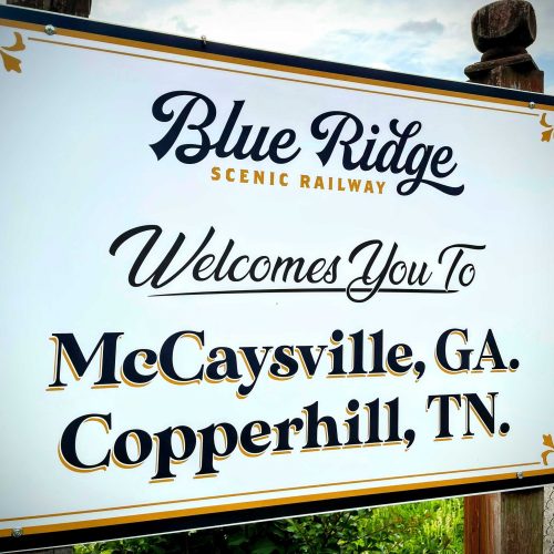 Sign for Blue Ridge Scenic Railway welcoming visitors to McCaysville, GA, and Copperhill, TN.