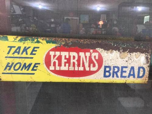 Vintage sign reading "Take Home Kern's Bread" with a weathered yellow and red design.
