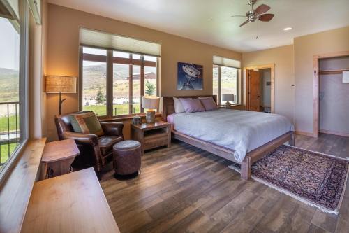 Cozy bedroom with a large bed, wooden furniture, and scenic views through large windows.