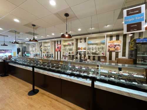 A candy shop display featuring various chocolates and sugar-free options in a well-lit, modern setting.