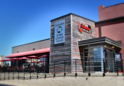 Exterior of a sushi lounge with a wooden facade, featuring a sign that reads "Satarana Sushi Lounge Fusion."