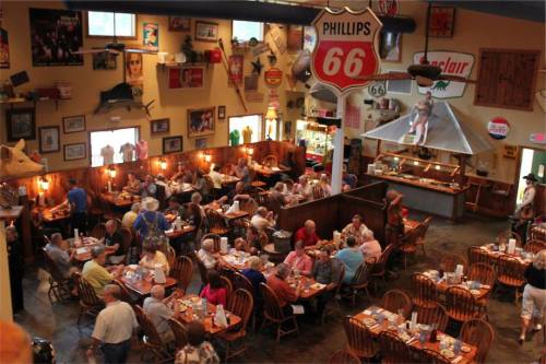A bustling restaurant filled with diners, vintage decor, and memorabilia on the walls, creating a lively atmosphere.