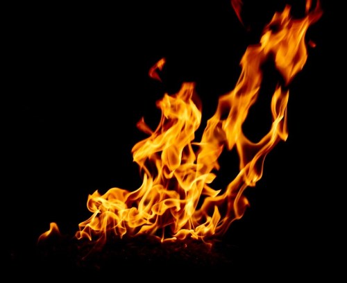 Bright orange and yellow flames dancing against a black background, creating a dynamic and fiery display.