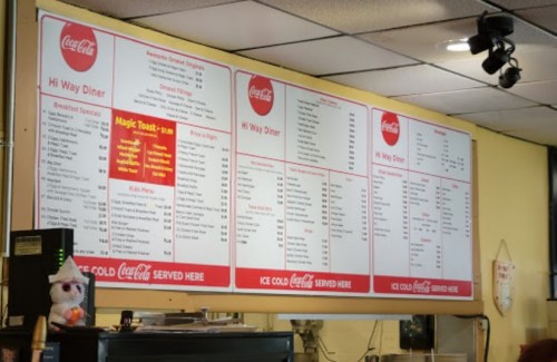 Menu board at a diner featuring breakfast, lunch, and dinner options with prices displayed.