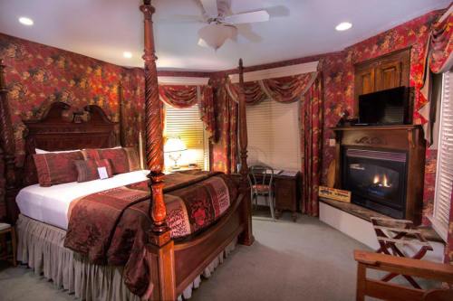 Cozy bedroom with a four-poster bed, floral wallpaper, fireplace, and elegant decor. Warm and inviting atmosphere.