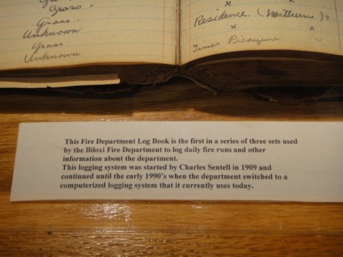 Image of a log book with handwritten entries and a note explaining its history and use by the Biloxi Fire Department.