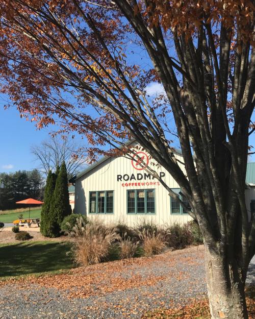 A coffee shop named "Roadmap Coffeeworks" with autumn leaves and a clear blue sky in the background.