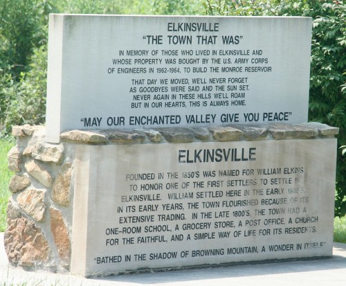 A stone monument commemorating Elkinsville, detailing its history and the community's legacy.