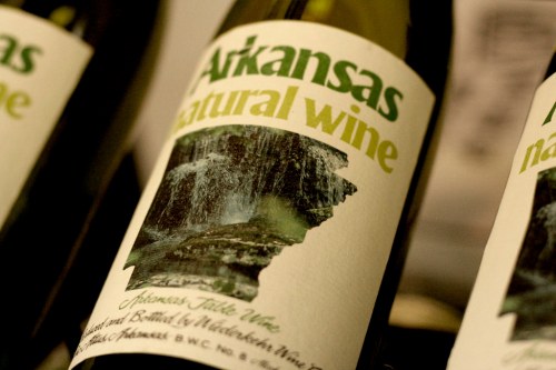 Label of Arkansas natural wine featuring a silhouette of the state and an image of a waterfall.