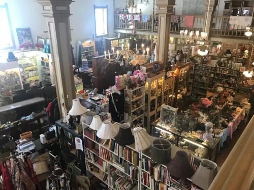 Aerial view of a vintage shop filled with various antiques, lamps, books, and decorative items.