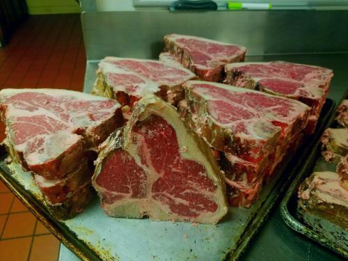 A tray of thick, marbled beef steaks arranged neatly, showcasing their rich red color and fat distribution.