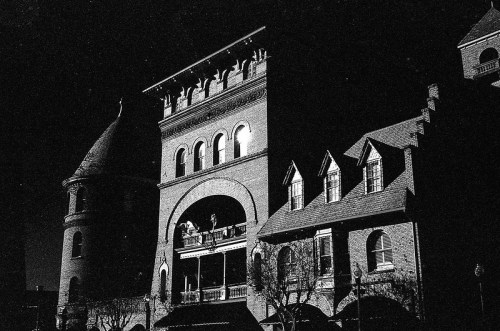 A historic building at night, featuring intricate architecture and illuminated windows against a dark sky.