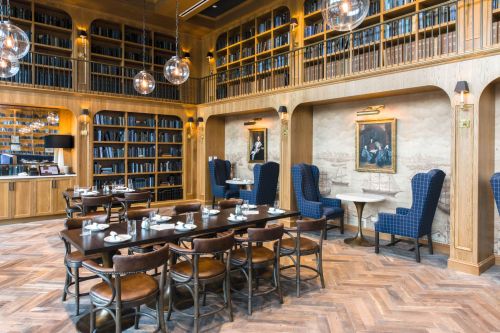 Elegant restaurant interior featuring wooden shelves, plush seating, and a warm ambiance with decorative lighting.
