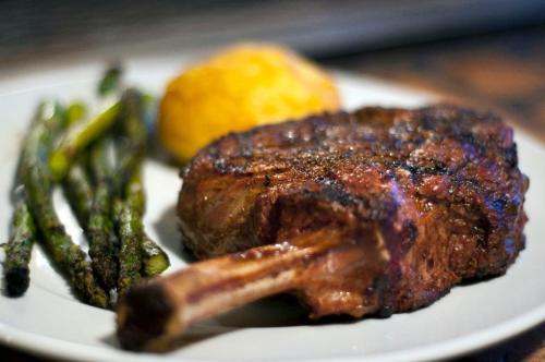 A plate featuring a grilled ribeye steak, asparagus, and a side of mashed potatoes.