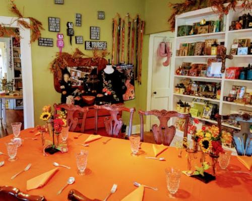 A cozy dining room decorated with autumn themes, featuring a festive table setting and colorful wall decor.