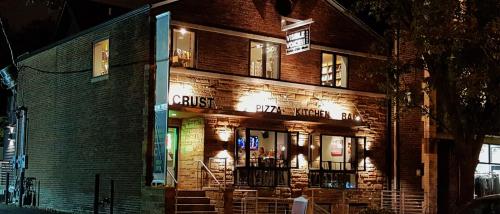 A cozy pizza restaurant at night, featuring a warm glow from its windows and a welcoming sign.