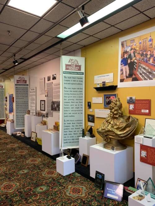 Interior view of a museum exhibit featuring displays, informational panels, and a large statue.