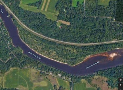 Aerial view of the Wisconsin River winding through lush green fields and forests.